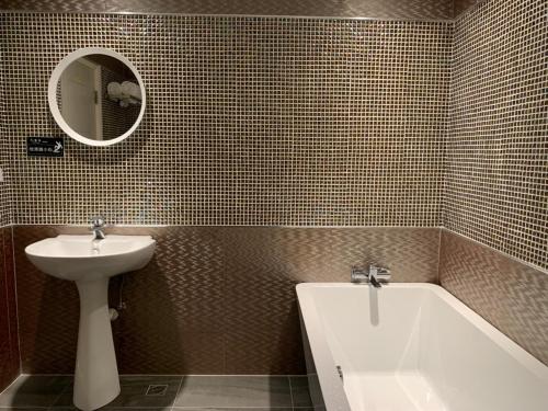 a bathroom with a sink and a bath tub and a sink at Roppongi Motel - JianHua in Pingtung City