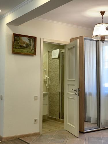 a bathroom with an open door and a shower at Restoran-hotel Stariy Melnik in Poltava