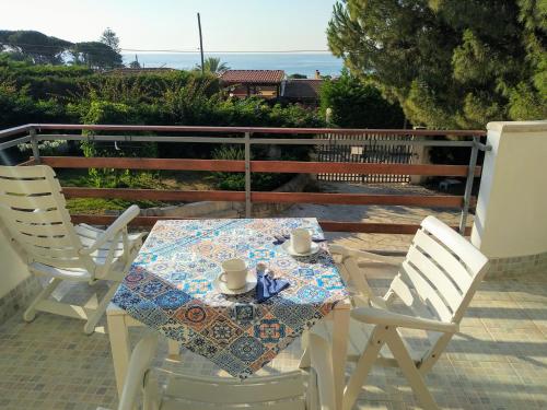 a table with two chairs and a table with two cups on it at VILLA VEGA in Fontane Bianche
