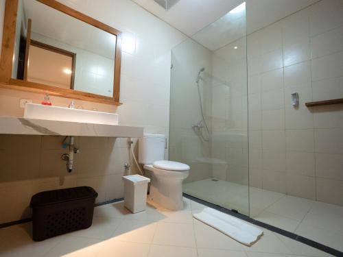 a bathroom with a shower and a toilet and a sink at Metta Agara in Kerobokan