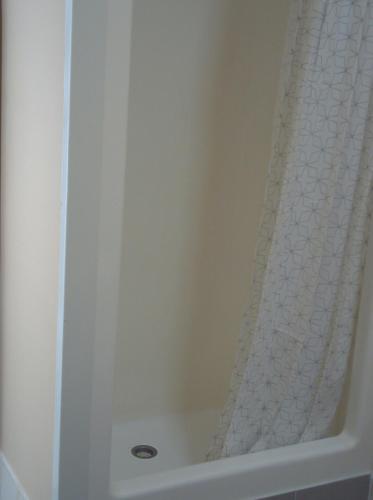 a shower in a bathroom with a shower curtain at iMotel Cooma (in town) in Cooma