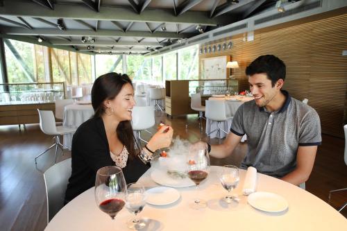 a man and woman sitting at a table in a restaurant at Hotel Món Sant Benet in Sant Fruitos de Bages