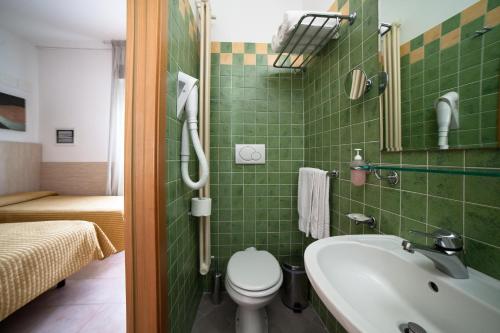 a bathroom with a toilet and a sink at Hotel Plaza in Rimini