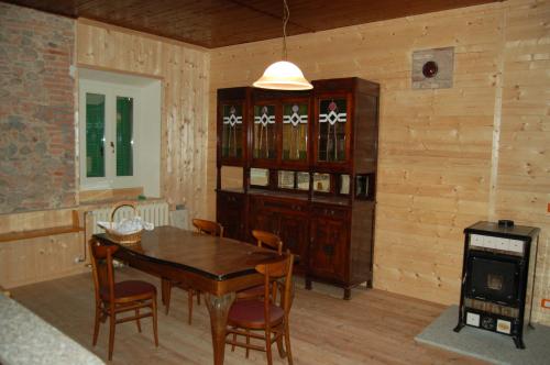 a dining room with a table and chairs and a stove at Laghi d'Insubria in Albizzate