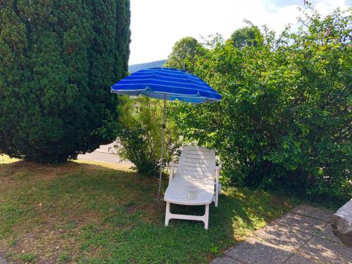 a chair and an umbrella in the grass at Auberge Pour Tous in Vallorbe