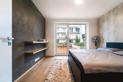 a bedroom with a large bed and a large window at In Apartments in Brno