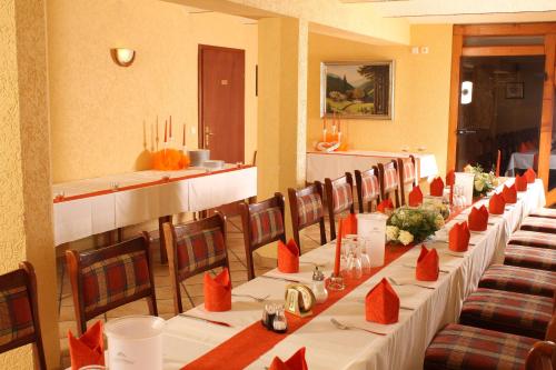 a dining room with long tables and chairs with red napkins at Pension Ferienhof Fischer in Freiberg