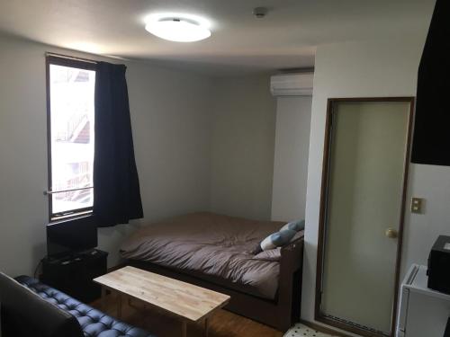 a small bedroom with a bed and a mirror at コンドミニアムホテル Stay inn Blue 301号室 in Hukue