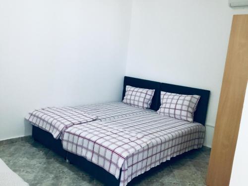 a bed with two pillows on it in a room at DK Apartmani in Dobra Voda