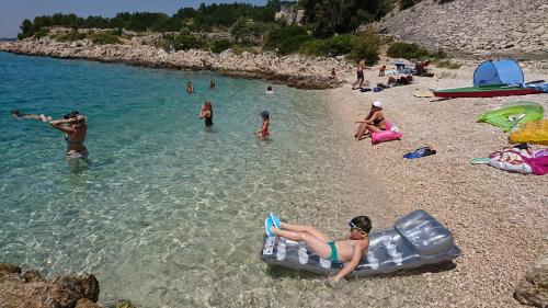 a group of people in the water at a beach at Apartments Dolac in Primošten