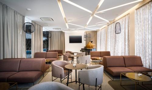 a waiting room with couches and chairs and tables at Valamar Carolina Hotel & Villas in Rab