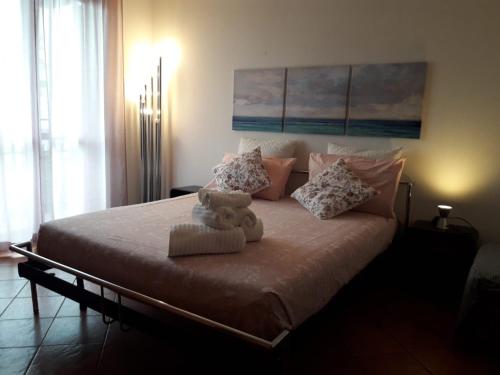 un lit avec un ours en peluche assis au-dessus dans l'établissement Porto Recanati Apartament, à Porto Recanati