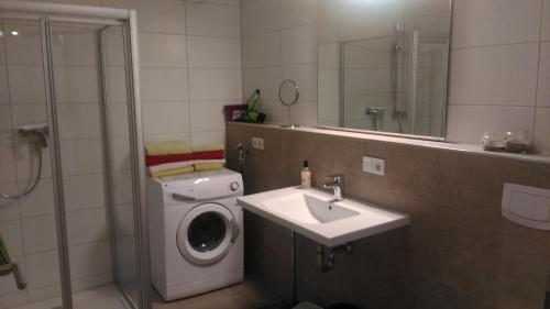 a bathroom with a washing machine and a sink at Ferienwohnung Am Verlorenen Bach in Untermühlhausen
