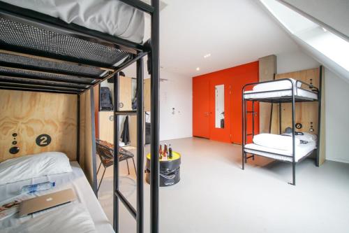 een kamer met 2 stapelbedden en een rode deur bij Via Amsterdam in Amsterdam