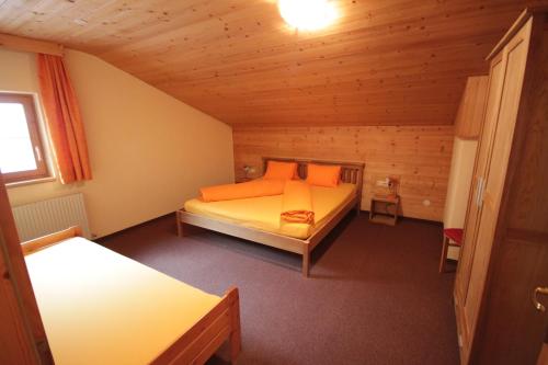 a bedroom with two beds in a wooden room at Haus Vallaster in Gaschurn