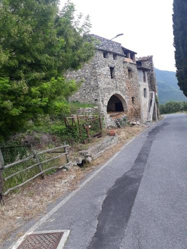 an old stone building on the side of a road at Agriturismo Nonnamelia in Nasino