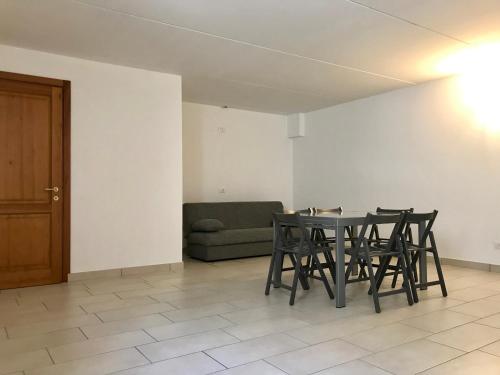 Un comedor con una mesa y sillas y un sofá. en Villetta Iris, en Garda