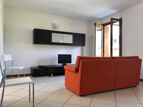 Una sala de estar con un sofá rojo y un televisor. en Villetta Iris, en Garda