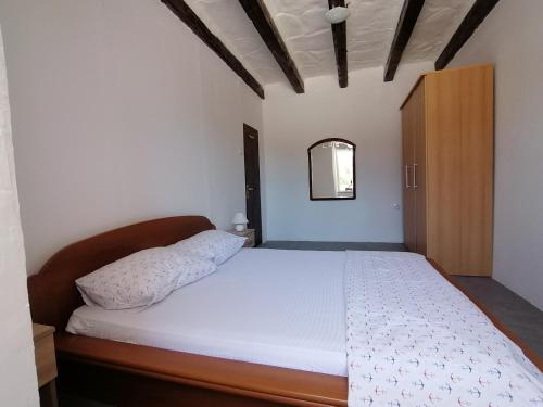 リエカにあるApartment Rinoの白いベッドと木製キャビネット付きのベッドルーム1室が備わります。