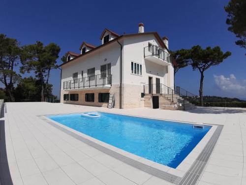 a large house with a swimming pool in front of it at Villa De Ruschi in Montacuto