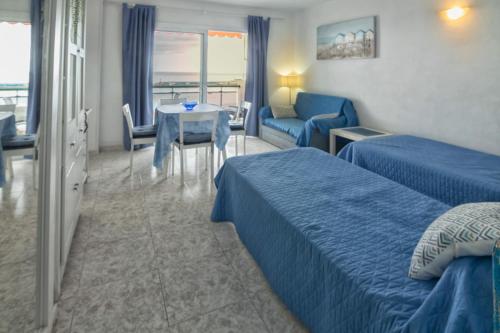 a hotel room with two beds and a table at Comodoro Estudio Vista Mar Explotaciones Ravel in Arona