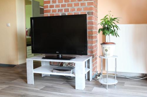 a tv on a white table in a living room at Ferienwohnung im Grünen in Diesbar-Seusslitz