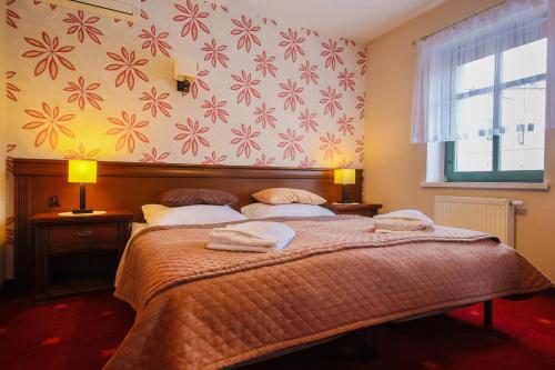 a bedroom with a bed with two towels on it at Apartamenty przy Głównym Deptaku in Wisła