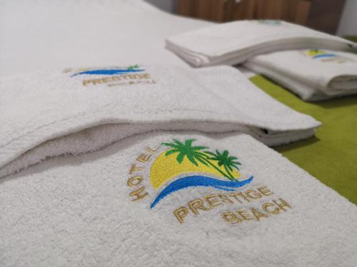 a towel with the words paradise island on it on a bed at Hotel Prestige Beach in Costinesti