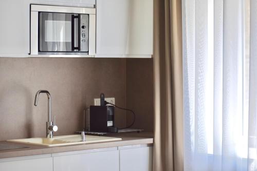 a kitchen with a sink and a microwave at Harmonia Palace in Budapest