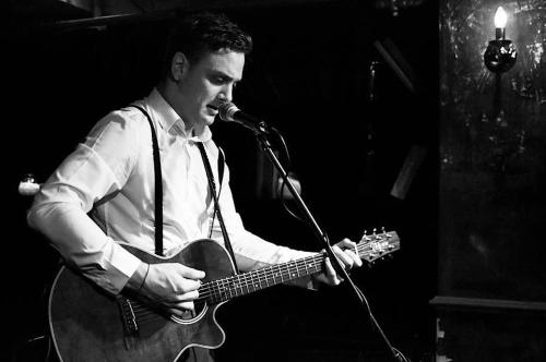 un hombre tocando una guitarra y un micrófono en St Christopher's The Inn - London Bridge en Londres