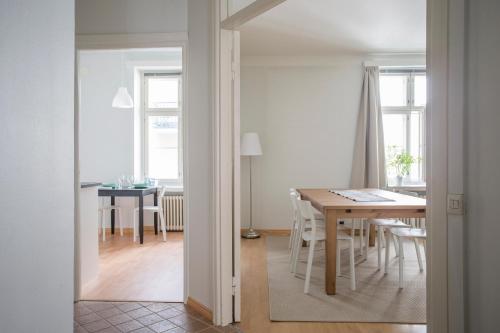 a kitchen and dining room with a table and chairs at 2ndhomes Gorgeous 2BR apartment by the Esplanade Park in Helsinki