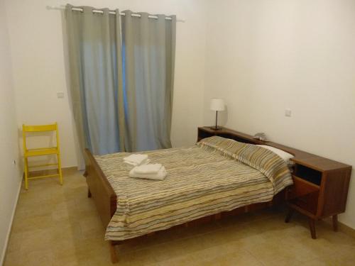 ein Schlafzimmer mit einem Bett mit zwei Handtüchern darauf in der Unterkunft Kymi Bay House in Platána