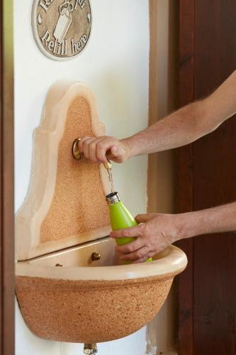a person is pouring a drink into a toilet at Hotel Villa Adriana in Monterosso al Mare
