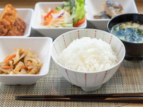 a table with bowls of rice and other foods at Super Hotel Kushiro-Ekimae in Kushiro