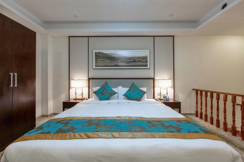 a bedroom with a large bed with two lamps at Guangzhou Seaman Club in Guangzhou