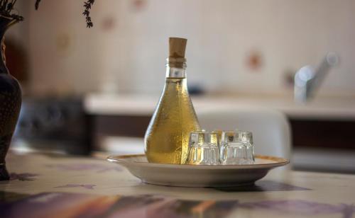una botella de vino en un plato con copas en Apartments Mediterranean Sundance, en Vodice