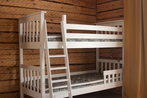 a room with two white bunk beds in a cabin at Pihtla Village Apartment in Pihtla
