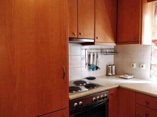 a kitchen with wooden cabinets and a stove top oven at Sior Dionysios in Argostoli