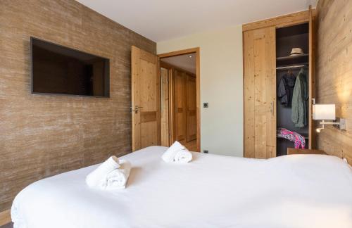 a bedroom with two beds and a flat screen tv at Résidence Daria-I Nor by les Etincelles in L'Alpe-d'Huez