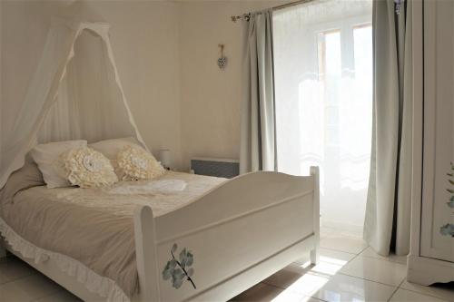 um quarto com uma cama de dossel branca em Gîte **** "le refuge des fées" em Saint-Julien-du-Gua