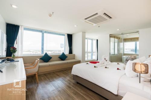 a hotel room with a bed and a couch at Rattanachol Hotel in Chon Buri