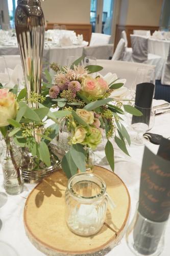 a table with flowers in vases on top of it at Hotel Fuchsen in Kirchheim unter Teck