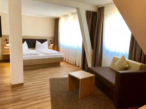 a hotel room with a bed and a couch at Flair Hotel Grüner Baum in Donaueschingen