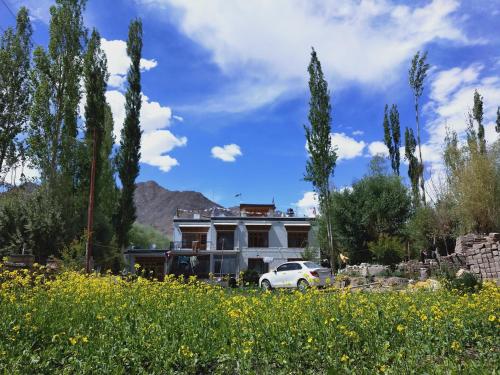 un coche blanco estacionado frente a una casa en Nilza Guest House, en Leh