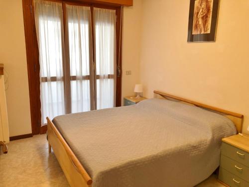 a bedroom with a bed and a large window at Al Faro in Grado