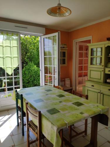 cocina con mesa, sillas y ventana en A 15 mn ouest Caen, en Noyers-Bocage