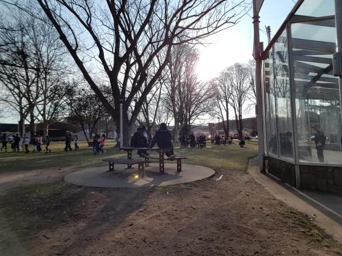 two people sitting on a park bench next to a building at iMotel Cooma (in town) in Cooma