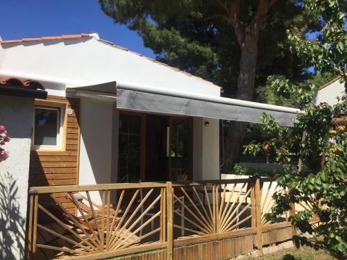 a house with a wooden fence and awning at Rêv'de Thau in Balaruc-les-Bains