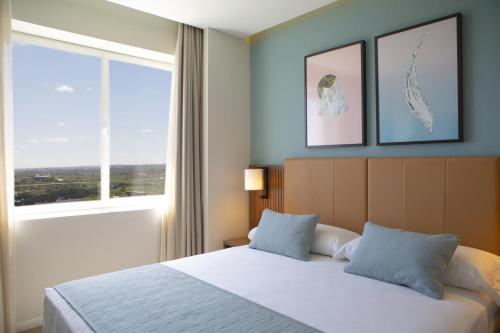 a bedroom with a bed and a large window at Riu Plaza España in Madrid