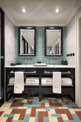 a bathroom with a sink and two mirrors at Bairro Alto Hotel in Lisbon